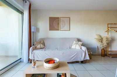 a living room with a bed and a cat on a table at Le Cosy Vignes - Piscine partagée in Azille