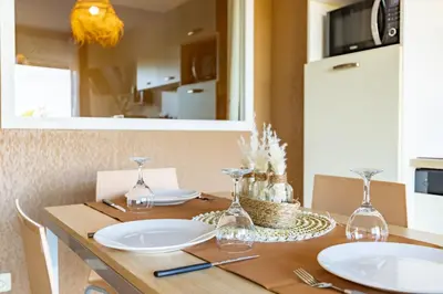 a dining room table with plates and glasses on it at Le Cosy Vignes - Piscine partagée in Azille