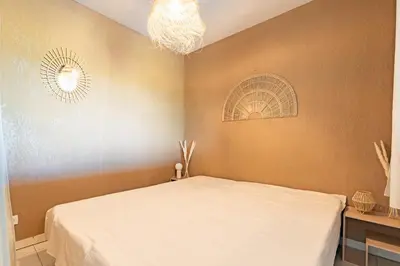 a bedroom with a bed and a chandelier at Le Cosy Vignes - Piscine partagée in Azille