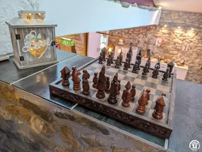 a wooden chess board on a table with a mirror at La maison millesime in La Caunette