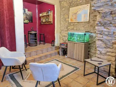 a living room with two chairs and a fish tank at La maison millesime in La Caunette