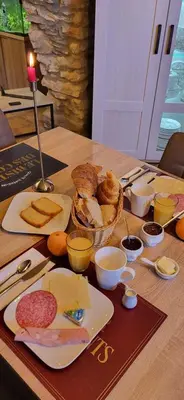 a table with a plate of bread and a basket of food at La maison millesime in La Caunette