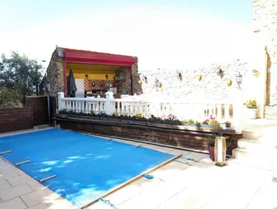 a swimming pool on a patio with a white fence at La maison millesime in La Caunette