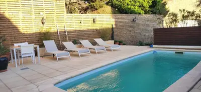 a group of chairs sitting next to a swimming pool at La maison millesime in La Caunette