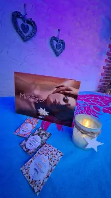 a table with a candle and a book and a candle at Love Room CHARME et PLAISIRS in Mazamet
