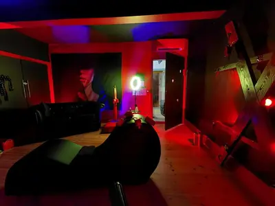 a living room with red and blue lights and a couch at Love Room CHARME et PLAISIRS in Mazamet