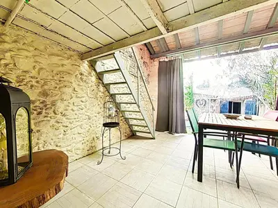a dining room with a table and a stone wall at Love Room CHARME et PLAISIRS in Mazamet
