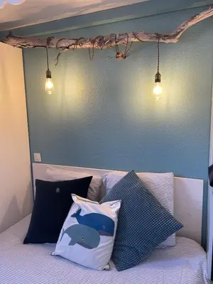 a bed with two pillows and a blue wall at Duplex plage des chalets Gruissan plage in Gruissan