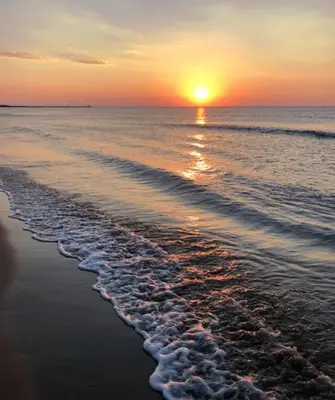 a sunset on a beach with the ocean at Duplex plage des chalets Gruissan plage in Gruissan