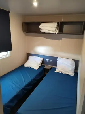 a small room with two bunk beds and towels at ZEN Mobil Home Occitanie 6P Tout confort & Climatisation in Port-la-Nouvelle