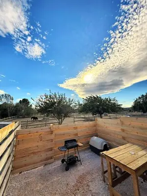 a wooden fence with a table and a grill at Studio à l'écurie 2 in Narbonne