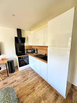 a kitchen with white cabinets and a white refrigerator at Studio à l'écurie 2 in Narbonne