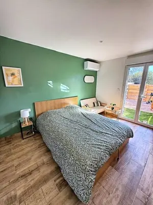 a bedroom with a bed and a green wall at Studio à l'écurie 2 in Narbonne