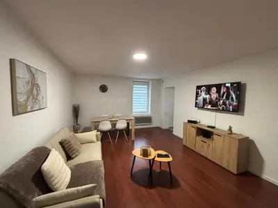 a living room with a couch and a tv at Maison cosy et chaleureuse in Pont-de-Larn