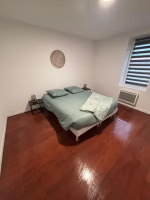 a bedroom with a bed and a wooden floor at Maison cosy et chaleureuse in Pont-de-Larn
