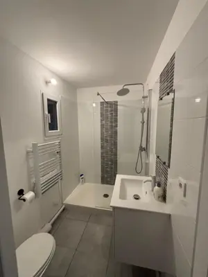a white bathroom with a toilet and a sink at Maison cosy et chaleureuse in Pont-de-Larn