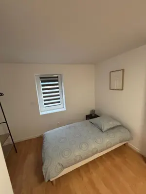 a bedroom with a bed and a window at Maison cosy et chaleureuse in Pont-de-Larn
