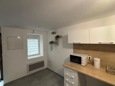 a kitchen with a counter with a microwave on it at Maison cosy et chaleureuse in Pont-de-Larn