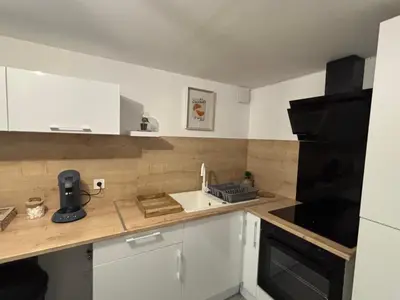 a small kitchen with a sink and a stove at Maison cosy et chaleureuse in Pont-de-Larn