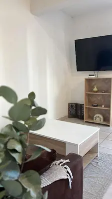 a living room with a white coffee table and a tv at Charming apartment with terrace and parking in Carcassonne in Carcassonne