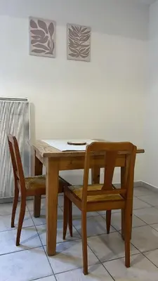 a wooden table with a chair and a wooden table and bench at Charming apartment with terrace and parking in Carcassonne in Carcassonne
