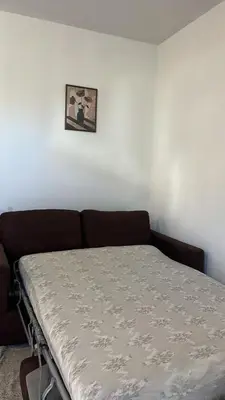 a bed in a room with a couch against a wall at Charming apartment with terrace and parking in Carcassonne in Carcassonne