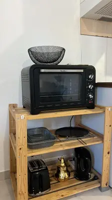 a microwave sitting on top of a wooden shelf at Charming apartment with terrace and parking in Carcassonne in Carcassonne