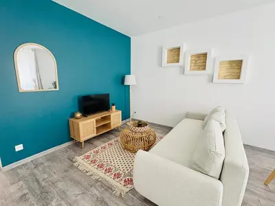 a living room with a couch and a tv at Le Soult l Rénové l Stationnement facile & gratuit in Mazamet