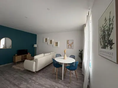 a living room with a couch and a table and chairs at Le Soult l Rénové l Stationnement facile & gratuit in Mazamet
