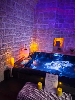 a table with plates and dishes on top of it at Loveroom, La Tour Secrete Jacuzzi, Sauna, plage, Clim, Netflix, Wifi Aude, occitanie in Vinassan
