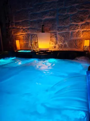 a jacuzzi tub with lights in a room at Loveroom, La Tour Secrete Jacuzzi, Sauna, plage, Clim, Netflix, Wifi Aude, occitanie in Vinassan