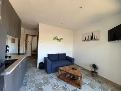 a living room with a blue couch and a table at Gîte de la Trémiére in Salles-d'Aude