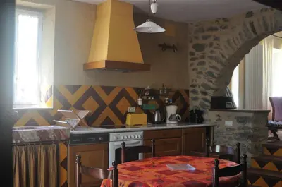 a kitchen with a table and a stove top oven at La maison du berger in Cassagnes