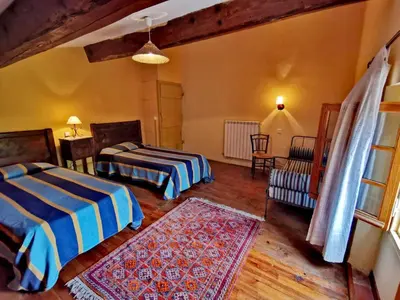 a bedroom with two beds and a table and chairs at La maison du berger in Cassagnes