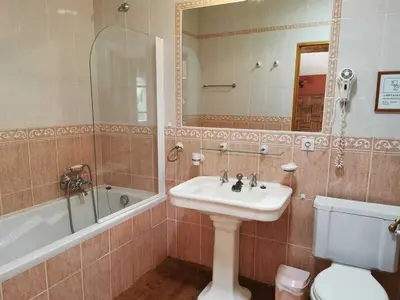 a bathroom with a sink and a tub and a toilet at La maison du berger in Cassagnes