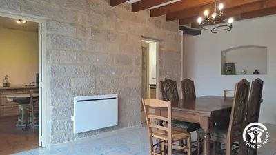 a dining room with a brick wall and a table and chairs at L'esquirou in Castres