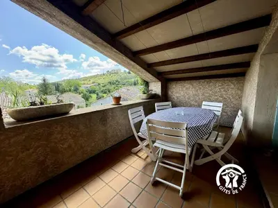 a patio with a table and chairs on a balcony at La marelle in Villerouge-Termenès