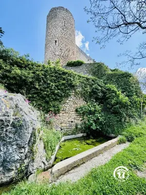 an old building with a clock tower on a hill at La marelle in Villerouge-Termenès