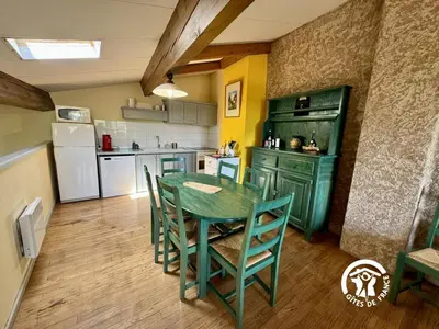 a kitchen with a green table and chairs at La marelle in Villerouge-Termenès