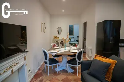 a kitchen and dining room with a table and chairs at Elegant T2 avec terrasse Coeur de Castelnaudary Gare in Castelnaudary