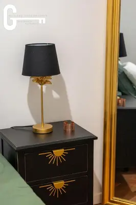 a lamp on a nightstand next to a mirror at Elegant T2 avec terrasse Coeur de Castelnaudary Gare in Castelnaudary