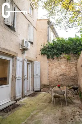 a table and chairs in front of a building at Elegant T2 avec terrasse Coeur de Castelnaudary Gare in Castelnaudary