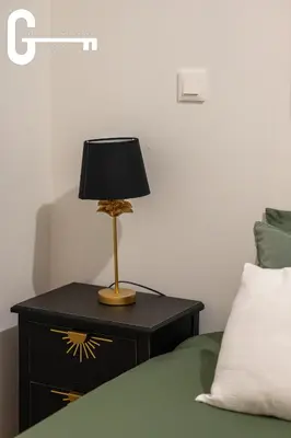 a lamp on a night stand next to a bed at Elegant T2 avec terrasse Coeur de Castelnaudary Gare in Castelnaudary