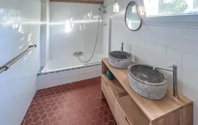 two sinks in a bathroom with a tub and a mirror at Amazing Home In Cazelles, Agel in Agel