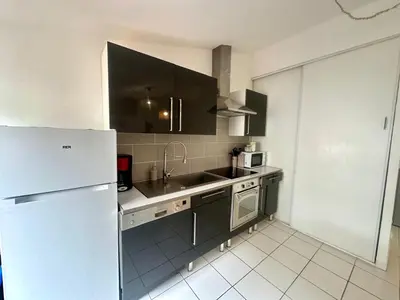 a kitchen with a sink and a refrigerator at Cosy Appartement 45 m2 en cœur de ville, proche gare in Narbonne