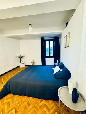 a bedroom with a large blue bed and a table at Grande maison de charme près de Carcassonne avec terrasse et jardin in Palaja