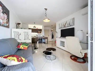 a living room with a couch and a tv at Le Pech - 6personnes - proche des plages - Clim in Gruissan