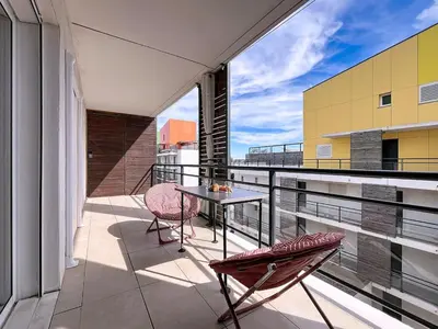 a balcony with a table and chairs on a building at Le Pech - 6personnes - proche des plages - Clim in Gruissan