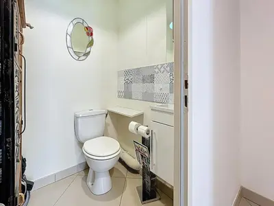 a white bathroom with a toilet and a mirror at Le Pech - 6personnes - proche des plages - Clim in Gruissan