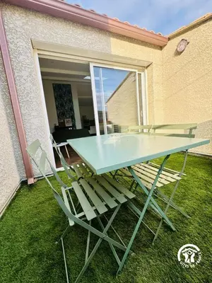 a blue table and chairs sitting on the grass at Gite de l'avenue in Sigean
